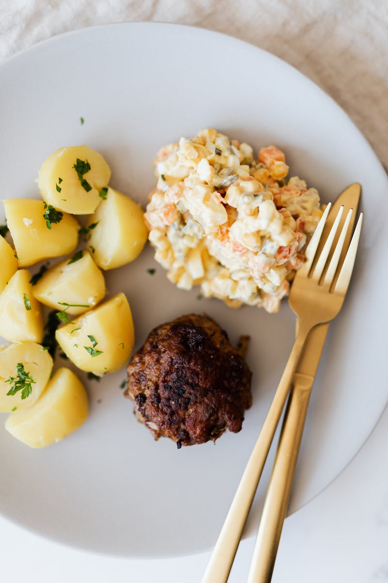 Appetizing meal of potatoes and patty with salad
