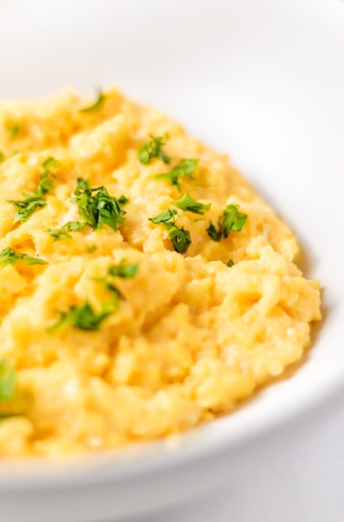 a bowl of mashed potatoes with parsley on top